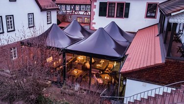 Bird's eye view of four event tents with a black roof