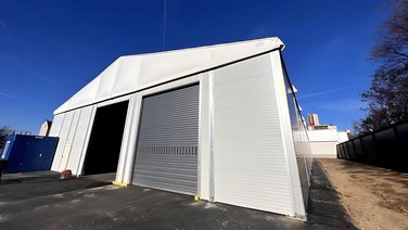 Front view and side view with view of a heated final production hall with roller doors