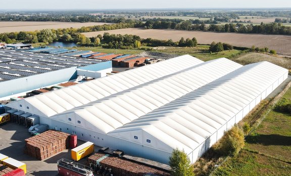 Vogelperspektive auf die mehrschiffigen Industriehallen mit dem Erweiterungsbau