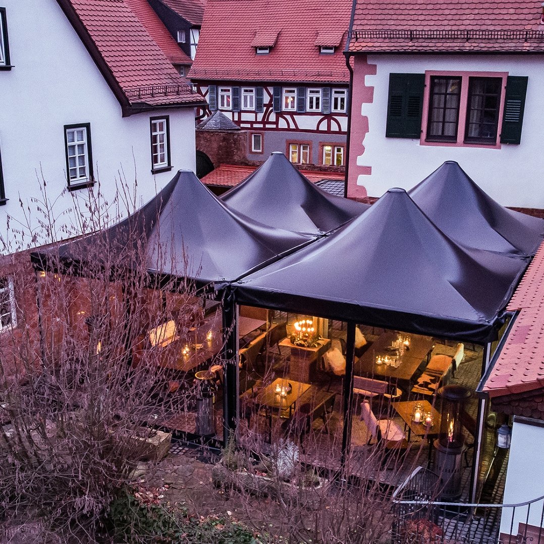 Inner courtyard of an open space of a restaurant with 4 event tents black Pvc tarpaulin