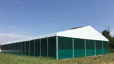 Back of an indoor riding arena with blue sky