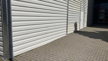 Side view of a vehicle hall for fire brigades with personnel door on the side