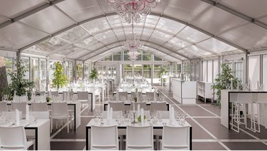 Interior view of a catering tent with stylish banquet seating