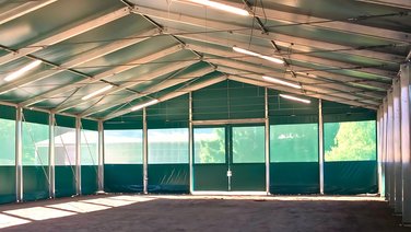 Interior view of an indoor riding arena with a view of the sliding gate