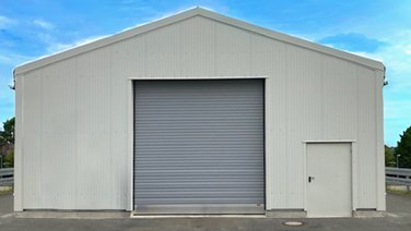 Front view of a warehouse with roller shutter door and personnel door