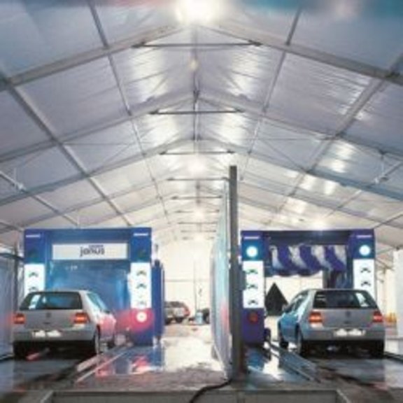 A car wash with two cars in an industrial tent