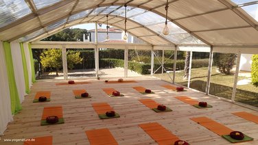 Interior view of a bodega tent with mats and yoga cushions