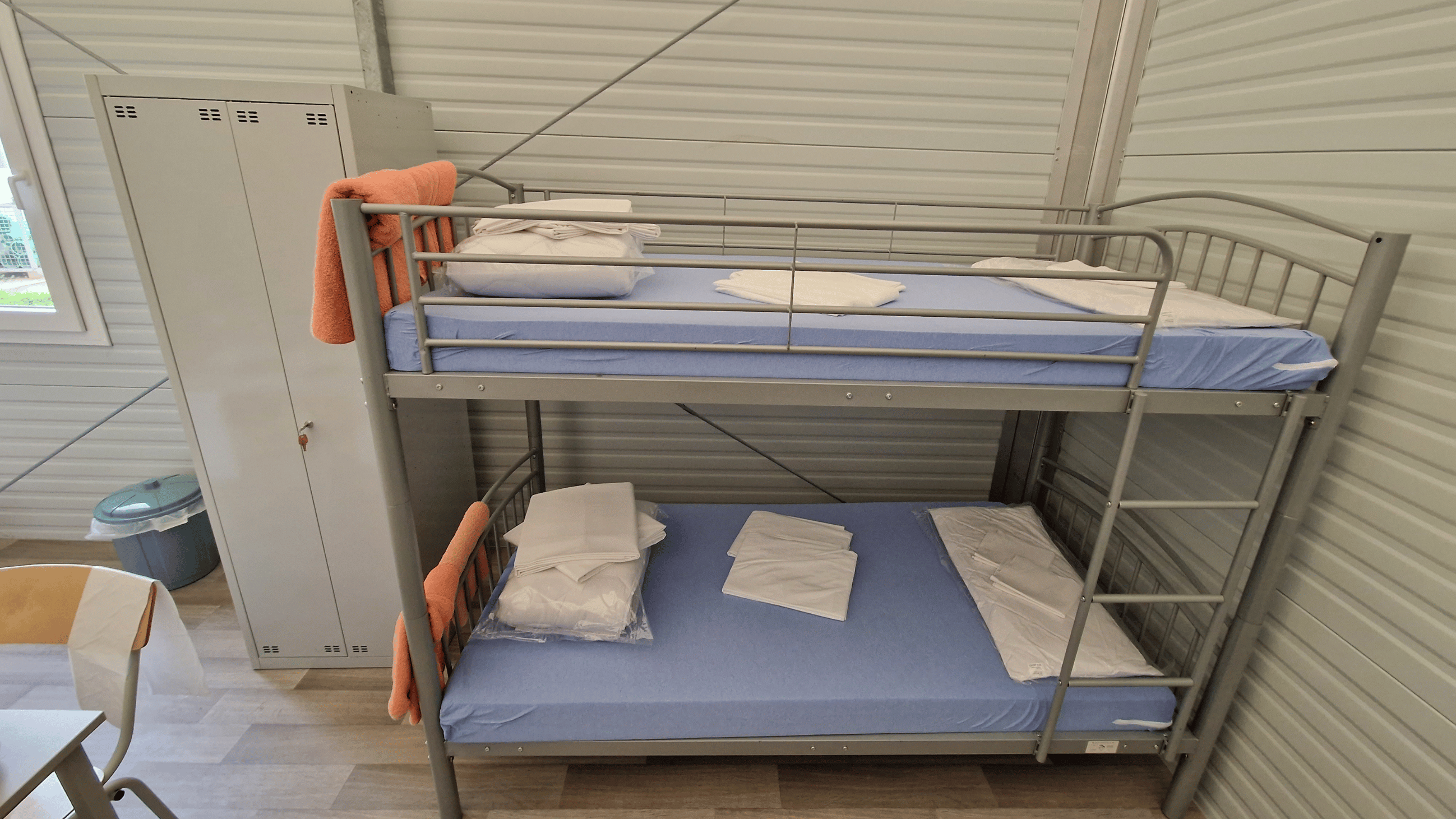 Flüchtlingsunterkunft mit Inneneinrichtung und Blick auf Etagenbett