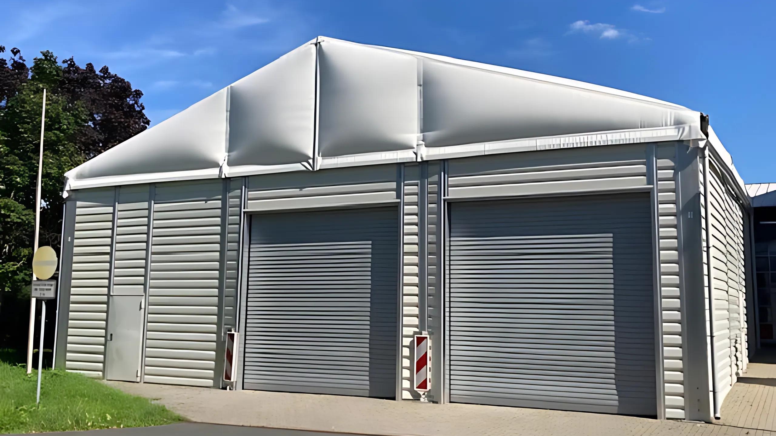 Front view of a vehicle shed with trapezoidal sheet metal façade and thermal roof tarpaulin Vorderansicht_einer_Fahrzeughalle_mit_Trapezblech_als_Fassade.jpg