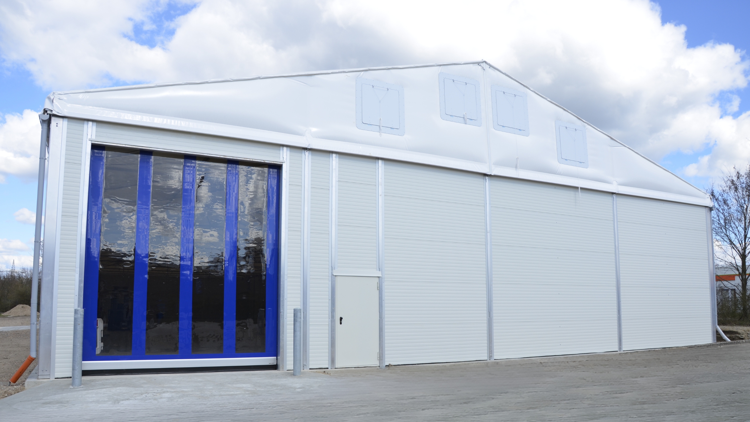 Front view of a lightweight hall with high-speed door Vorderansicht_einer_Leichtbauhalle_mit_Schnellrolltor_und_Personaltuer.jpg